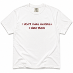 A white short-sleeve crewneck t-shirt with the text 'I don't make mistakes I date them' printed in dark red across the chest. The shirt is laid flat against a clean white background.
