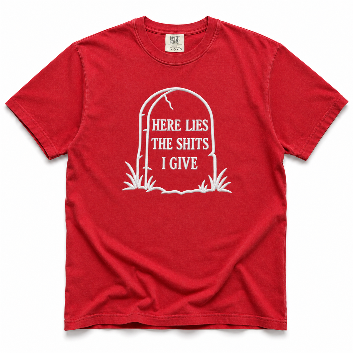 A red short-sleeve crewneck t-shirt with a white graphic of a tombstone on the chest containing the text 'HERE LIES THE SHITS I GIVE'.