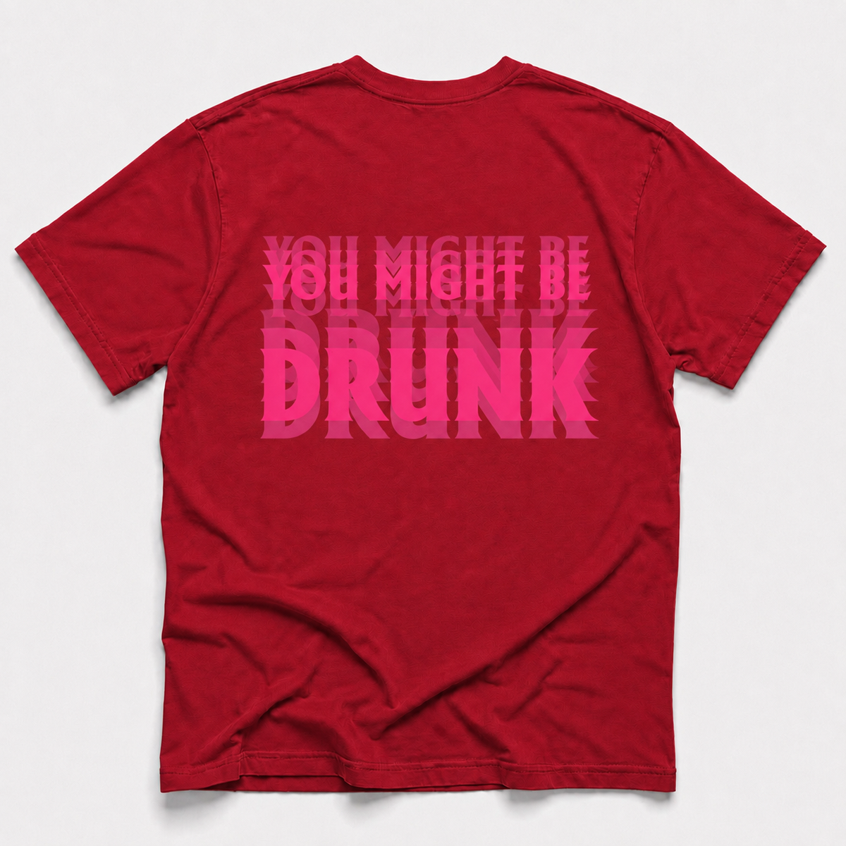 A red short-sleeve t-shirt shown from the back, featuring the phrase 'YOU MIGHT BE DRUNK' printed in a bold, layered pink font across the center.
