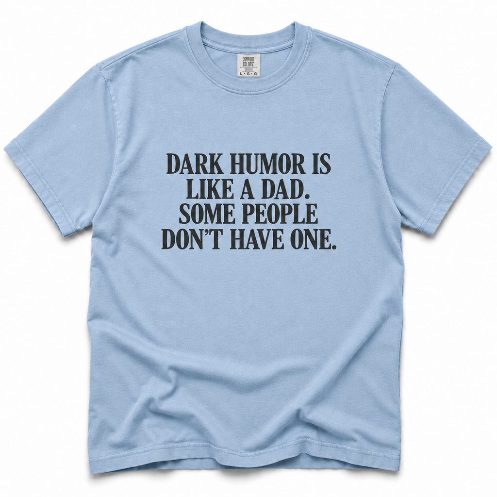 chambray crewneck t-shirt with a black printed text graphic on the chest that reads 'DARK HUMOR IS LIKE A DAD, SOME PEOPLE DON'T HAVE ONE.'.