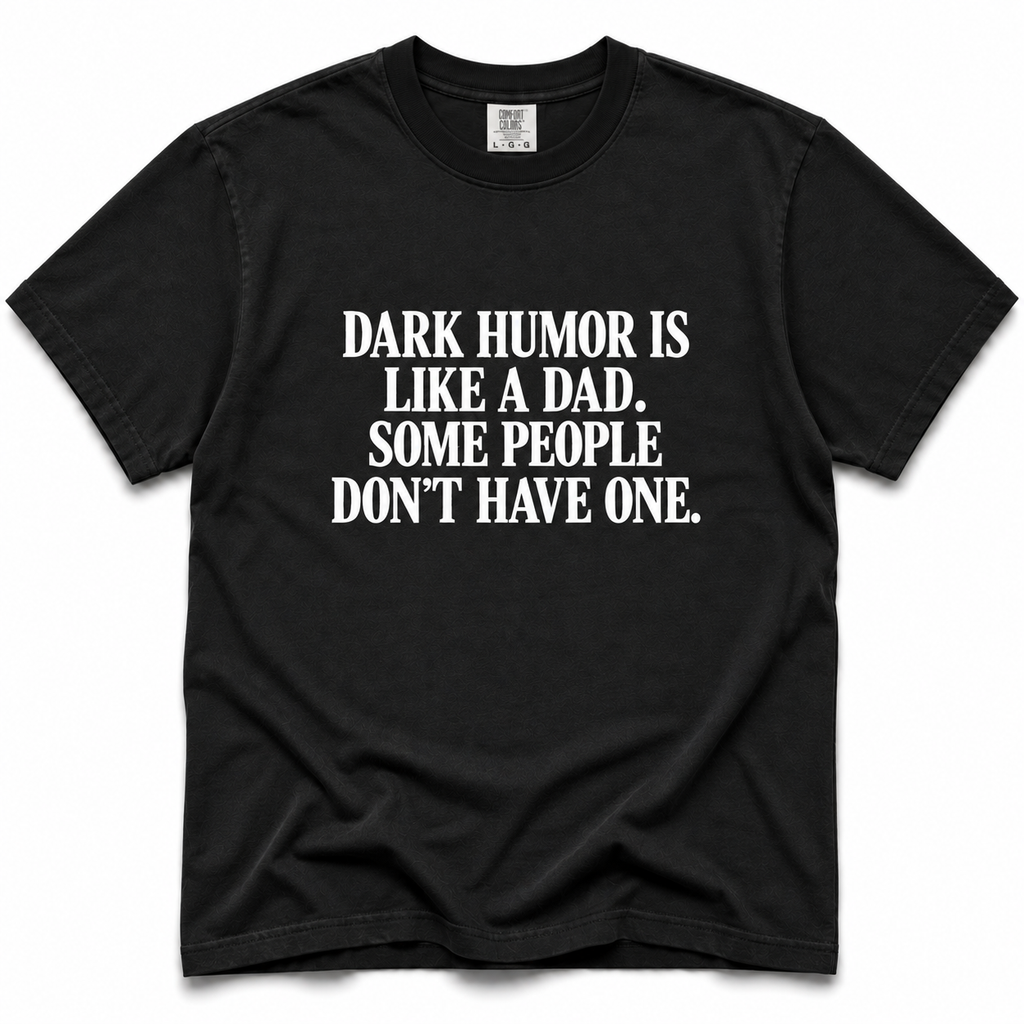 A black short-sleeve crewneck t-shirt with bold white text on the front reading 'DARK HUMOR IS LIKE A DAD. SOME PEOPLE DON'T HAVE ONE.