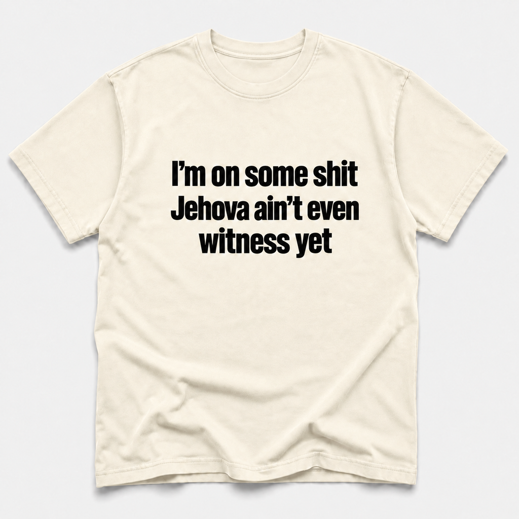 ivory crewneck t-shirt with the text 'I'm on some shit Jehovah ain't even witness yet' printed in black sans-serif font across the chest, displayed on a light gray background.