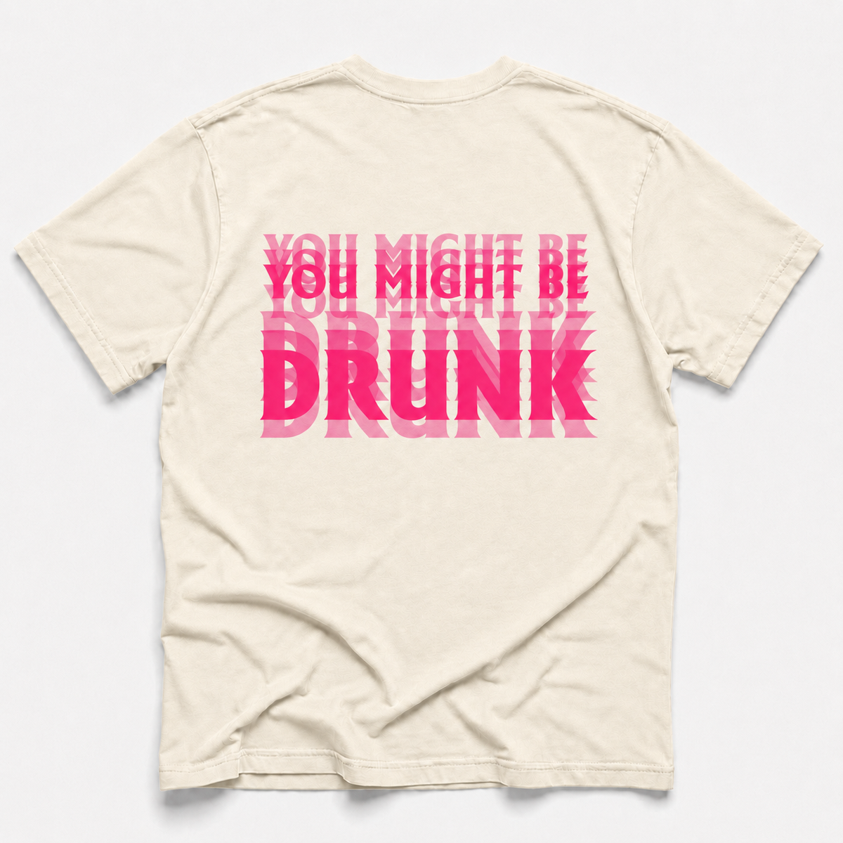ivory crewneck t-shirt shown from the back, featuring a bold graphic text print in shades of pink that reads 'YOU MIGHT BE DRUNK' in a layered, overlapping style.