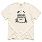ivory crewneck t-shirt with a black graphic of a tombstone that reads 'HERE LIES THE SHITS I GIVE' on a plain white background.