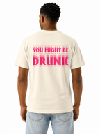 A man viewed from behind wearing an ivory-colored t-shirt with a bold pink graphic text on the back reading 'YOU MIGHT BE DRUNK', paired with light blue jeans, against a plain white background.